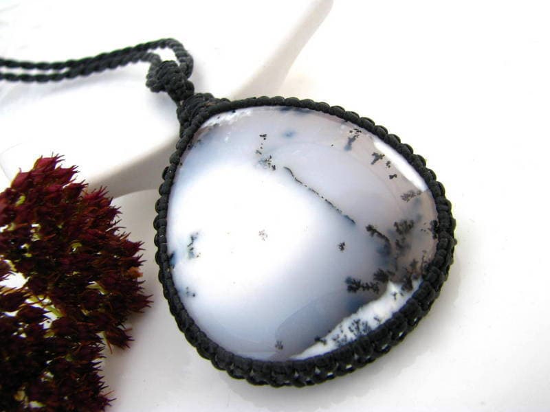 Model is wearing a teardrop Dendrite Opal macrame necklace, black and white merlinite gemstone